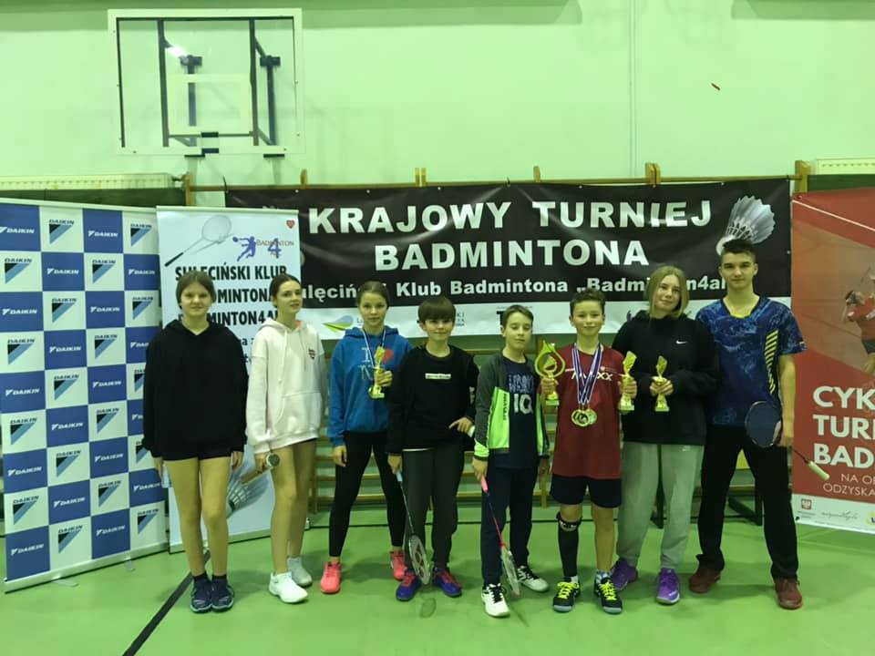Grupa młodych badmintonistów, stojąca w szeregu.